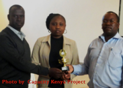 Evelyn Wambui receives a transformational award from Capacity Kenya’s, Mathew Thuku and CHAK’s Patrick Kyalo