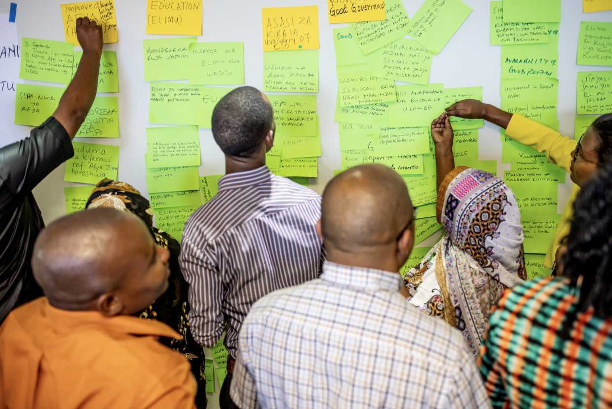 Pact staff and community members in Tanzania take part in a workshop before the Covid-19 pandemic to gather ideas for improving Pact’s programming