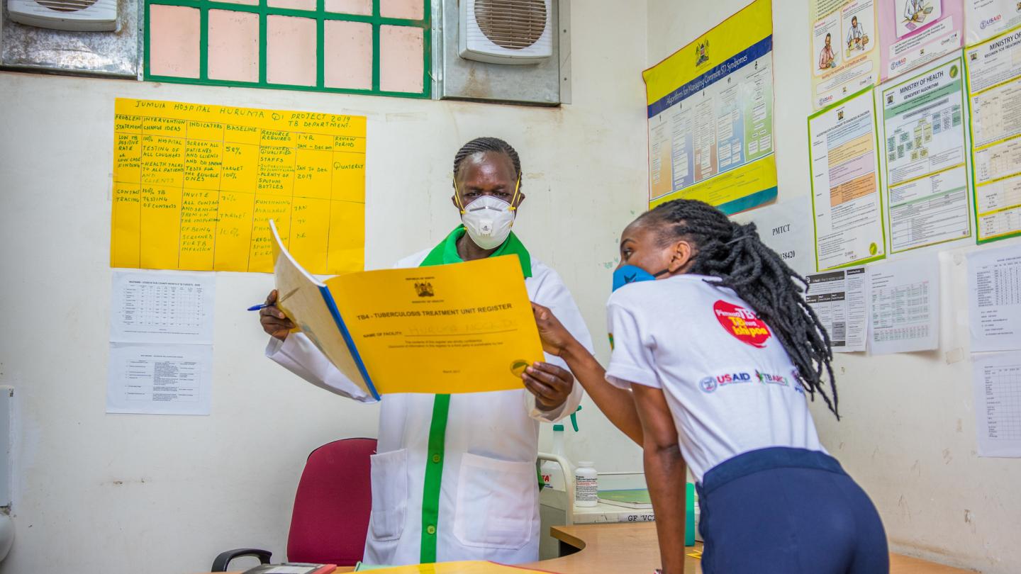 A nurse and patient advocate in Kenya review patient registration from an outreach event.
