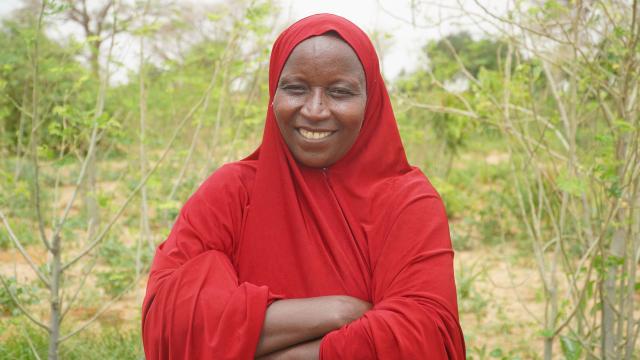Smiling woman in red hijab with arms crossed