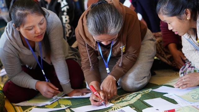 Participants of USAID Laos Microenterprise wear lanyards with QR codes during a training.