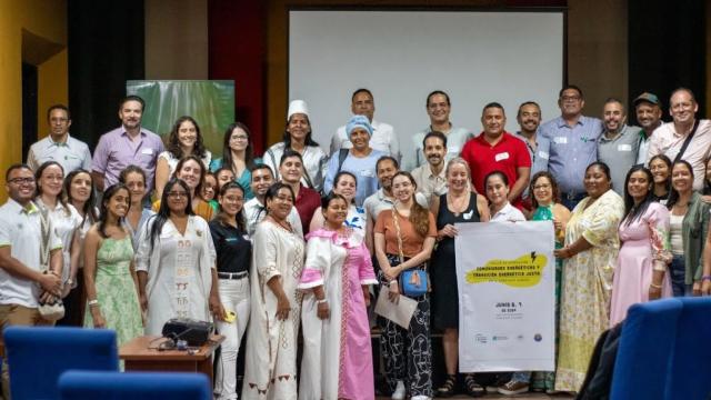 A large group of people pose for a photo at a conference