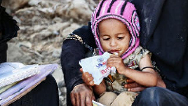 A child in Yemen eats a ready-to-use therapeutic food bag